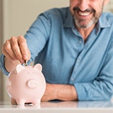Man putting money into a piggy bank
