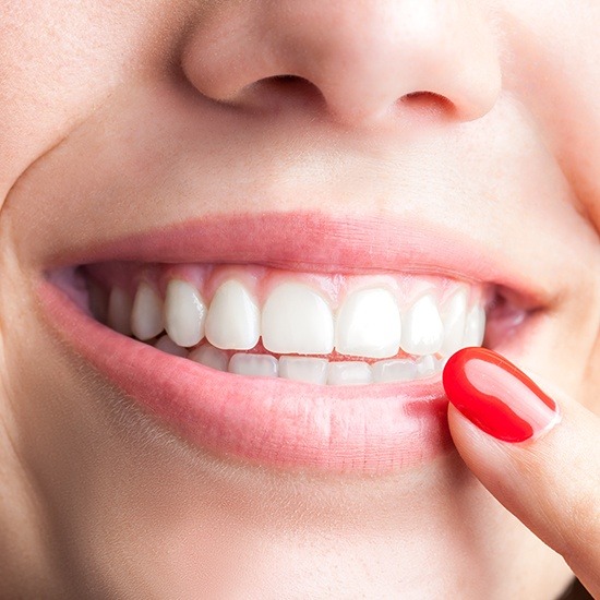 Woman pointing to smile after periodontal therapy