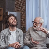 Older man telling a story to a younger man