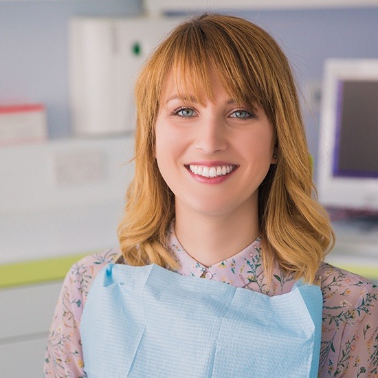 Woman in floral shirt smiling during dental checkup and teeth cleaning visit