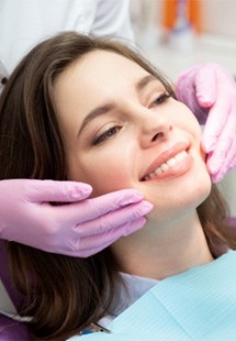 woman smiling in dental mirror