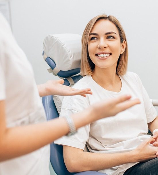 Dentist speaking with female patient