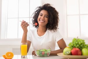 woman eating salad as one of her New Year’s resolutions 