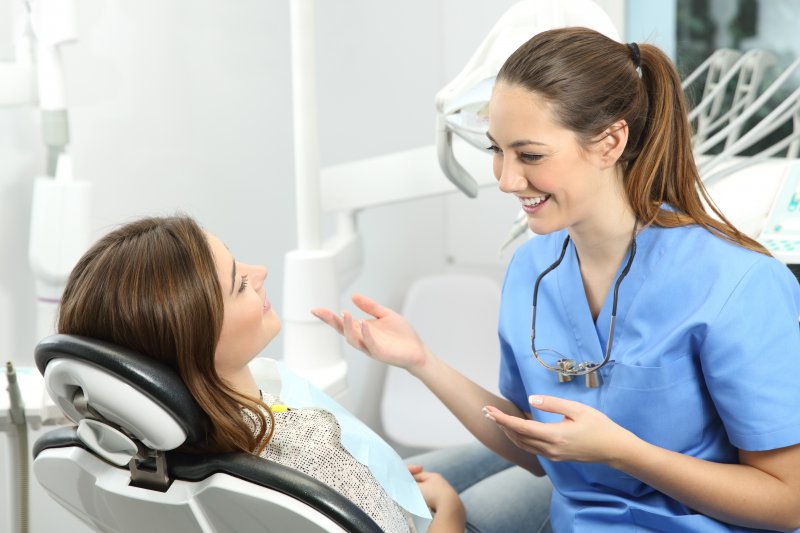 dentist teaching patient about dental hygiene best practices 