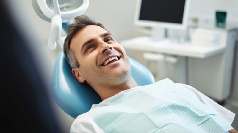 A man in the dentist's chair smiling as he undergoes sedation dentistry