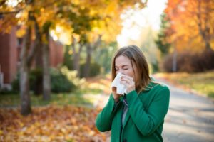 A women sneezing in a park